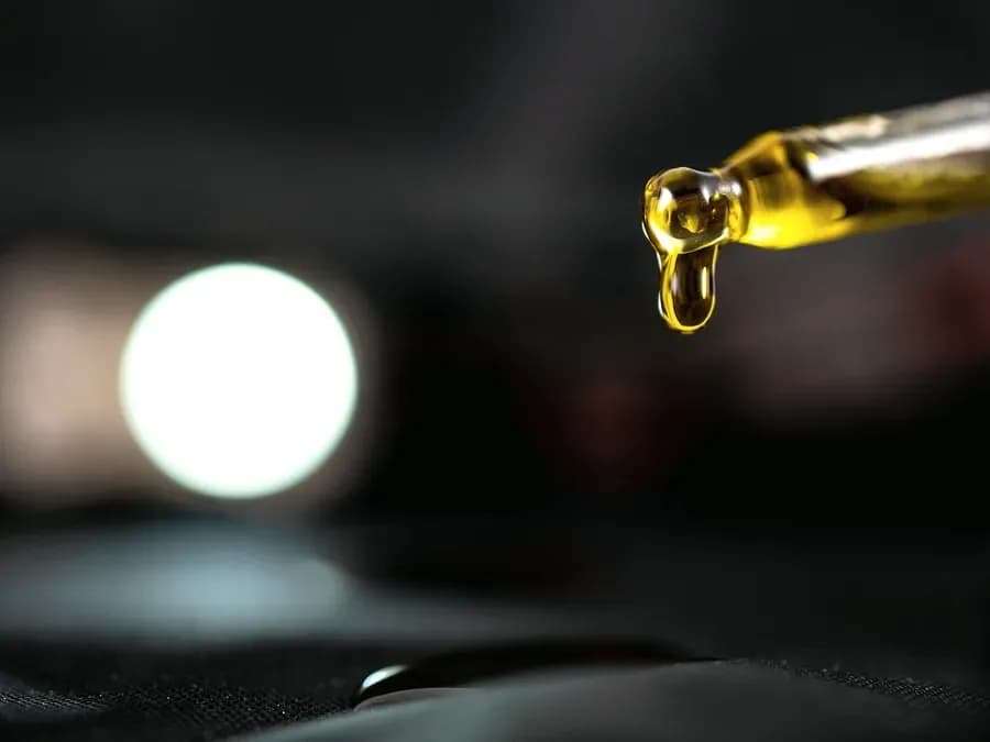 Dropper releasing a drop of oil